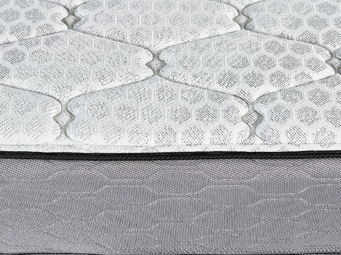 Close-up of a quilted mattress surface with hexagonal pattern.
